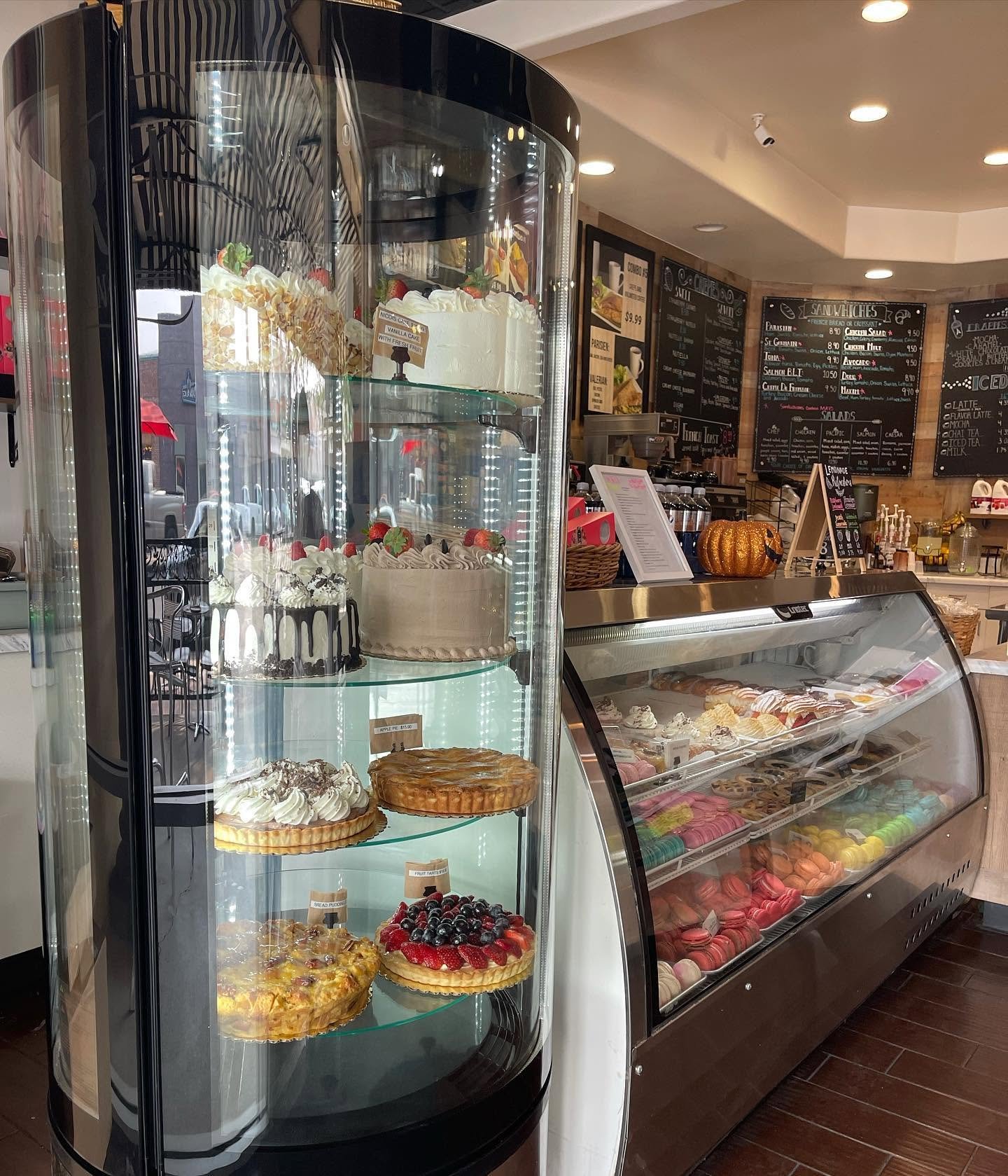 Inside Parisien Bakery — display cases of cakes, tarts and macarons