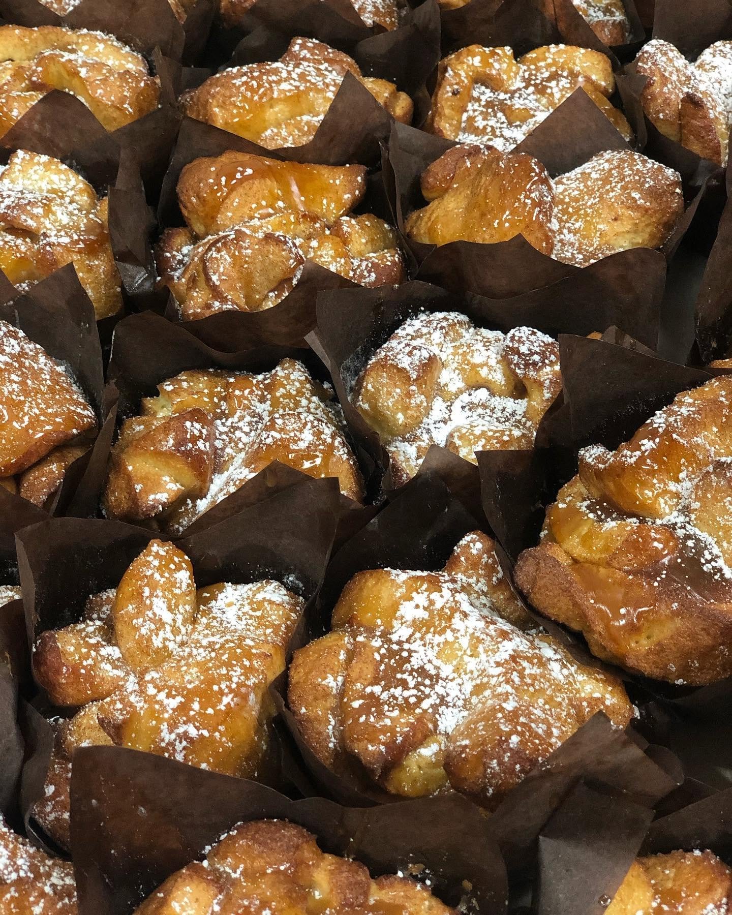Fresh-baked pastries dusted with powdered sugar at Parisien Bakery