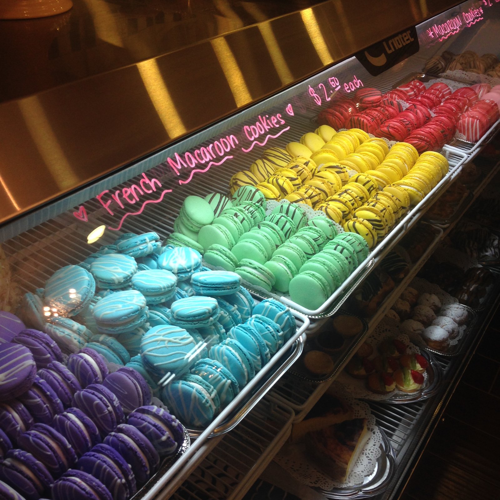 Rainbow display case of colorful French macarons
