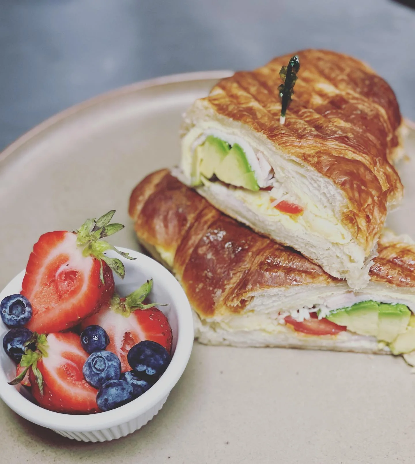 Turkey and avocado croissant sandwich with fresh berries